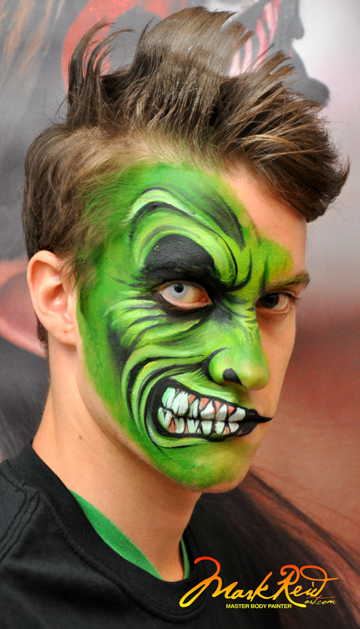 teenage boy with the right side of his face painted with a green monster contrasting the unpainted left side of his face